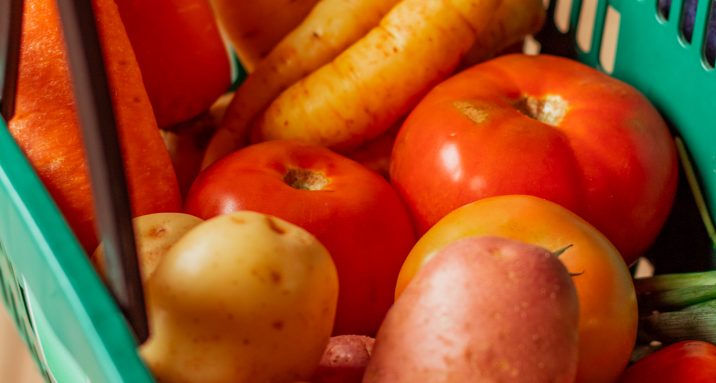 Cliente segurando sua cesta de compras, com alimentos saudáveis e de qualidade.