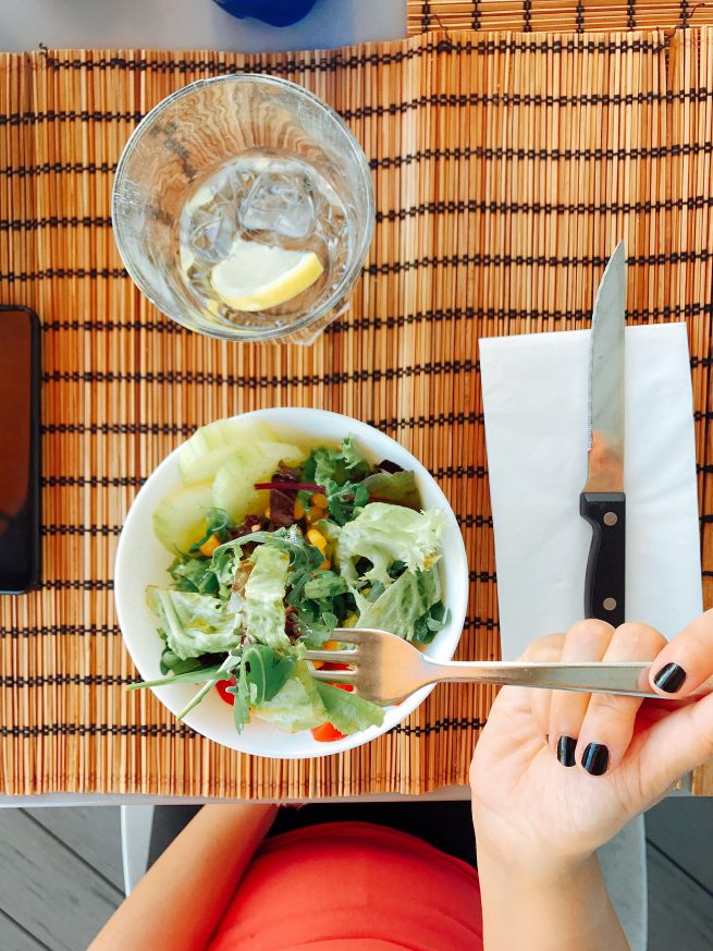 Comendo em pouca quantidade apenas a salada, por conta da dieta restritiva.