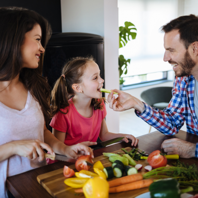 Pais tratando sua filha com uma alimentação saudável.