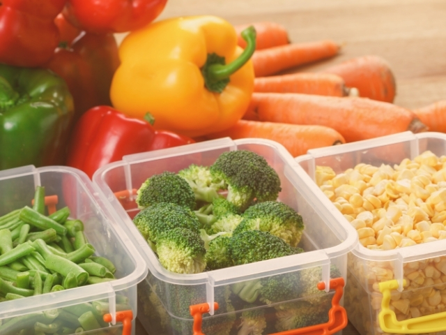 Vários recipientes de plástico, com verduras e legumes.