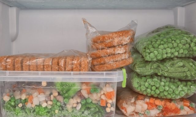 Alimentos empacotados em alguns sacos plásticos e em potes, para o congelamento.