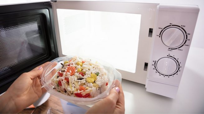 Colocando o prato de comida para esquentar no microondas.