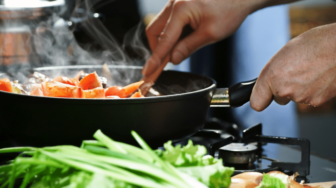 Cozinhando uma variedade de vegetais de folhas verdes.