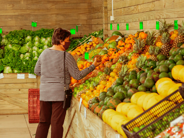 Cliente escolhendo as melhores frutas e verduras de safra para sua semana.